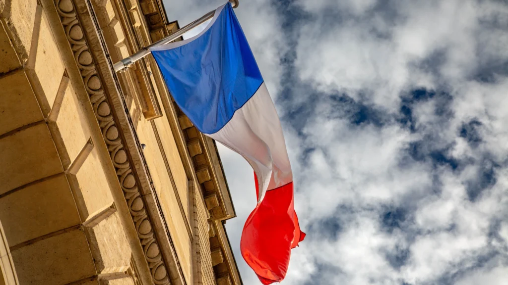 Bandiera francese sventola su un edificio istituzionale per la legge contro ultra fast fashion
