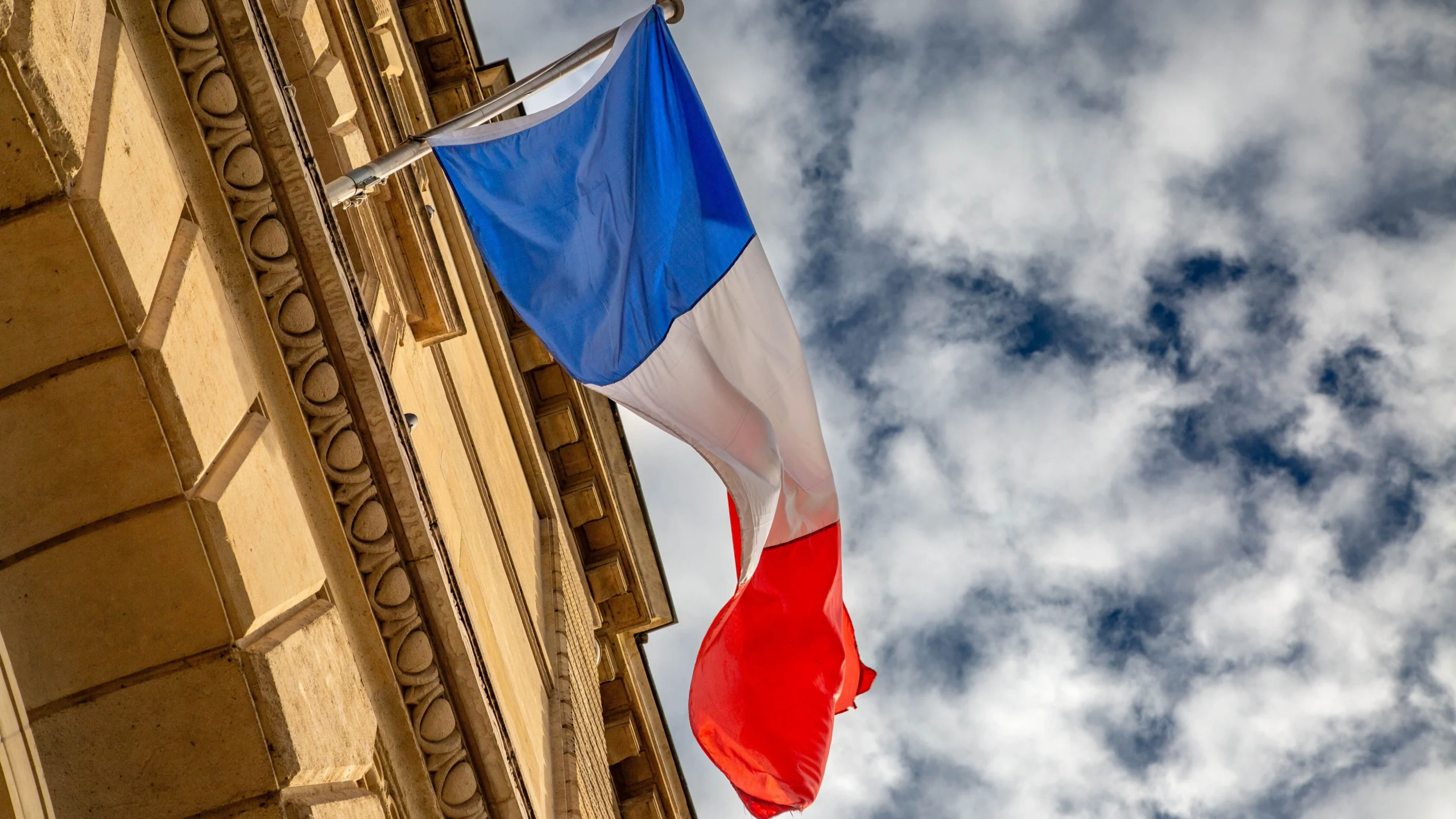 Bandiera francese sventola su un edificio istituzionale per la legge contro ultra fast fashion