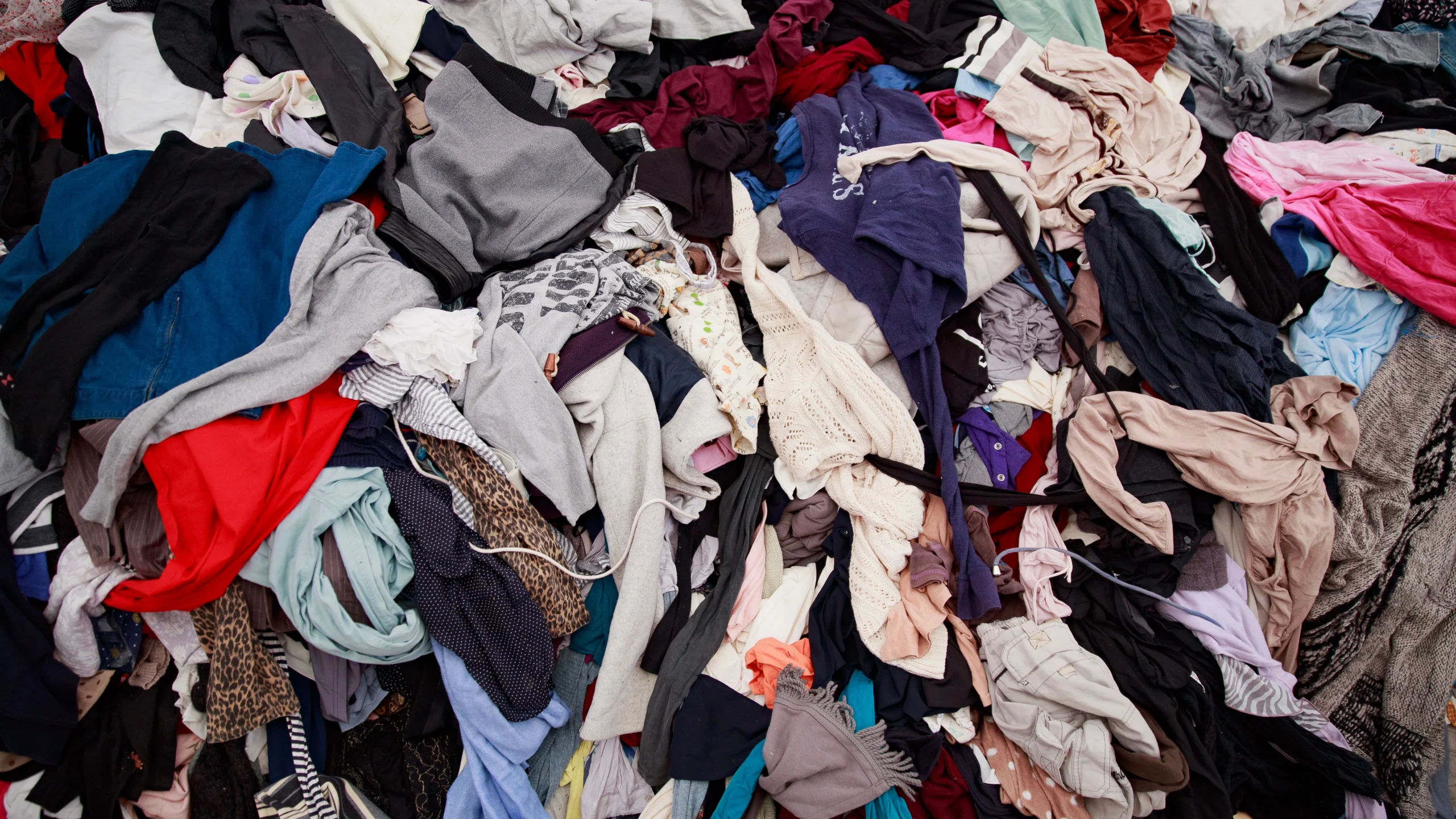 Accumulo di vestiti usati e rifiuti tessili sovrapproduzione moda