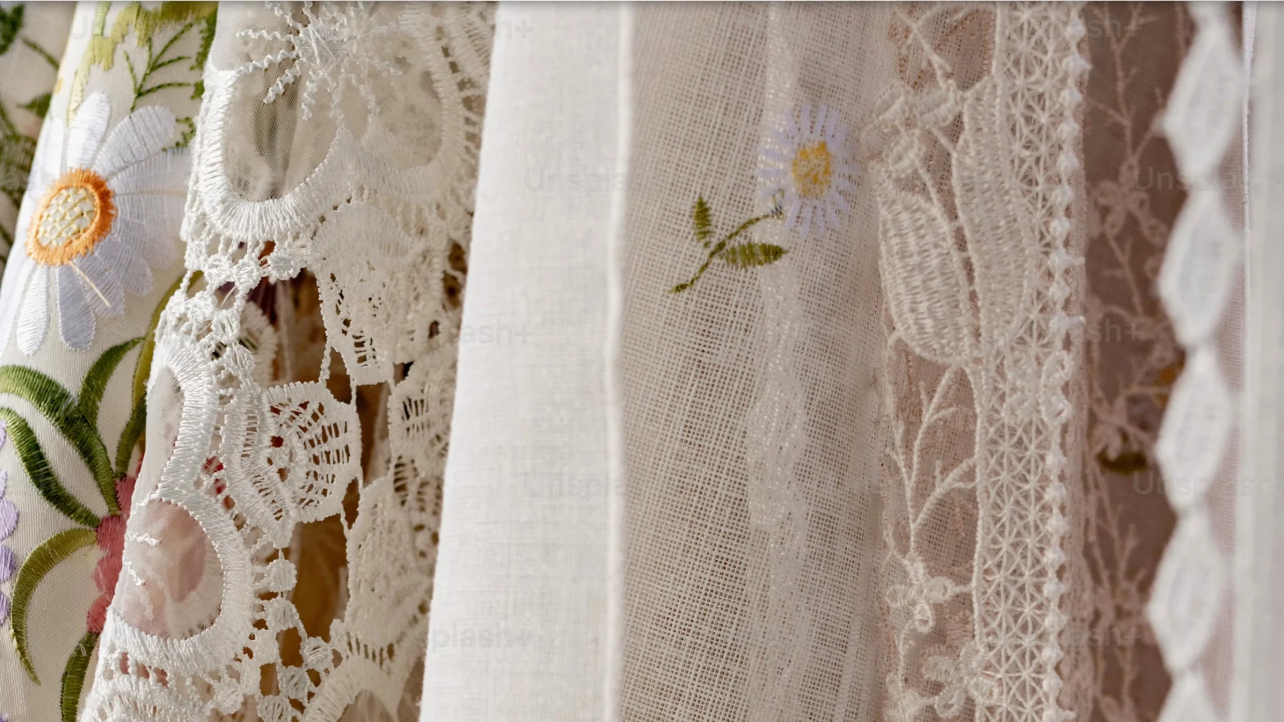 Dettaglio macro di tessuti d'epoca in pizzo bianco e lino con ricami floreali in stile boho chic - Foto Laura Adai