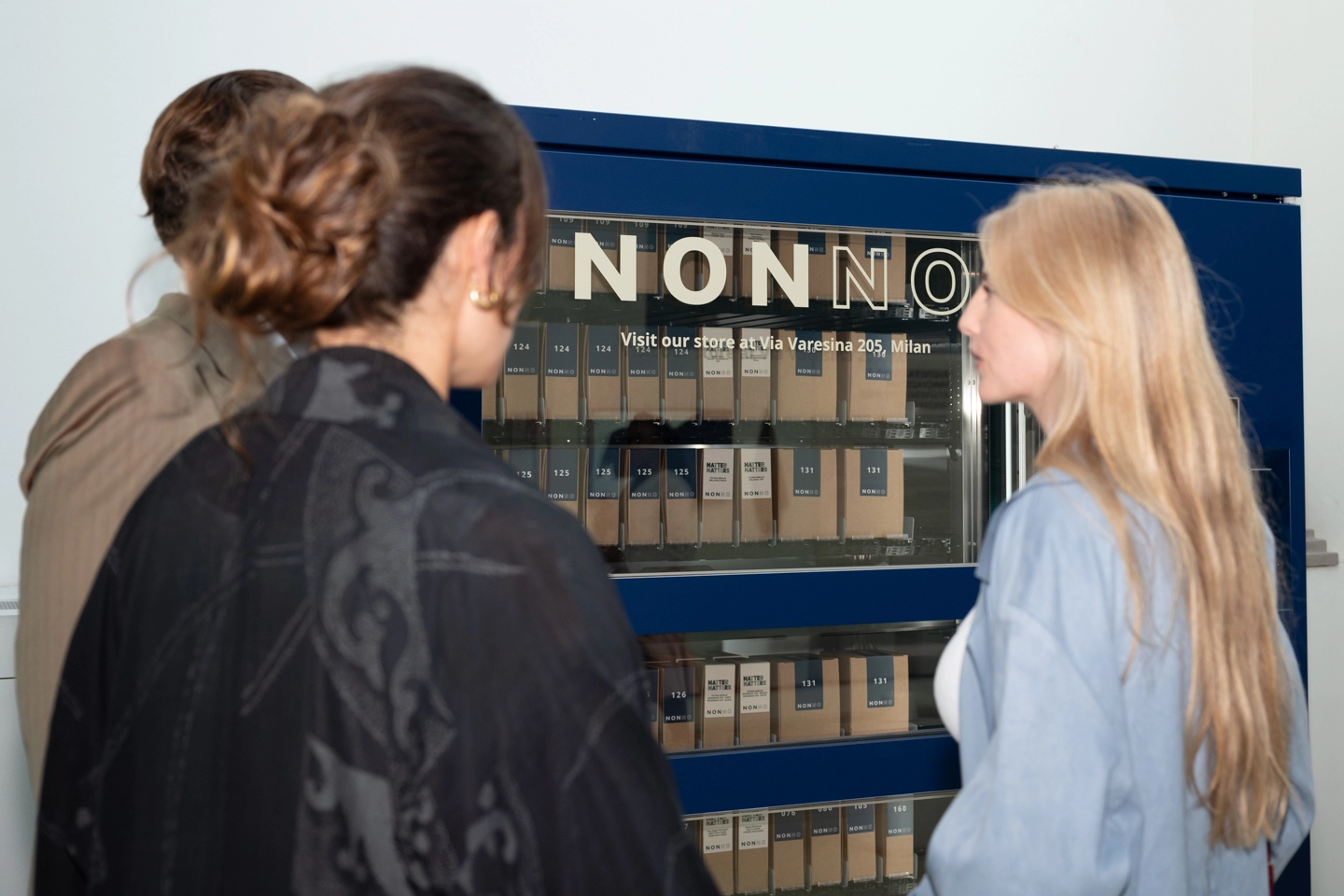 Visitatori che osservano il distributore automatico del sistema NONNO alla mostra MATTER MATTERS. Foto di Luigi Colonna.