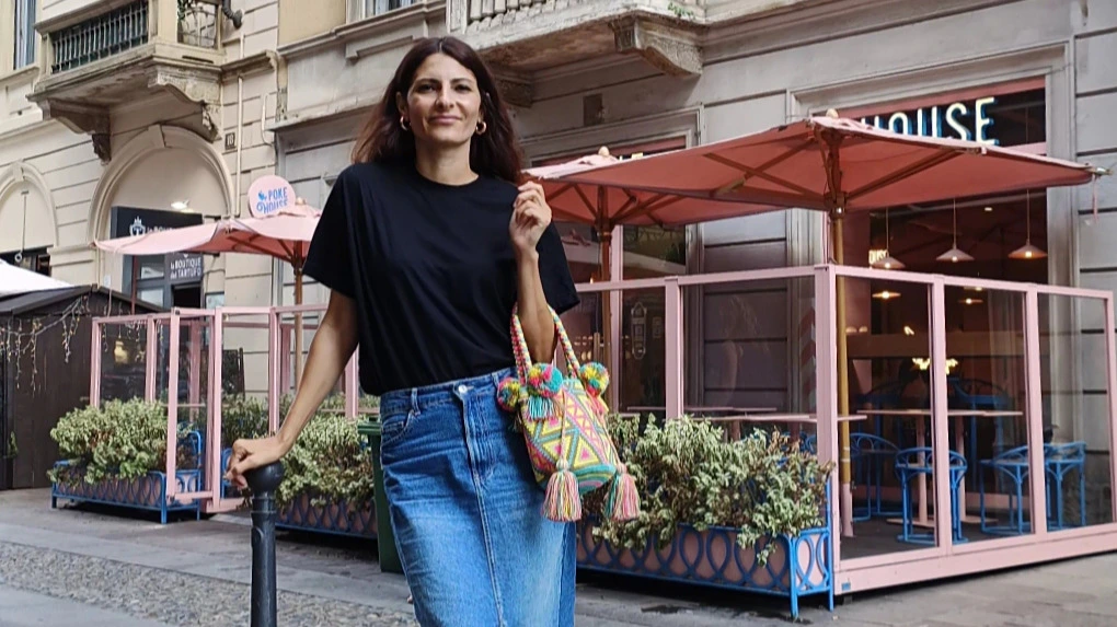 Silvia Ferrari fondatrice di Mochila Milano sorride in strada con una borsa Wayuu colorata