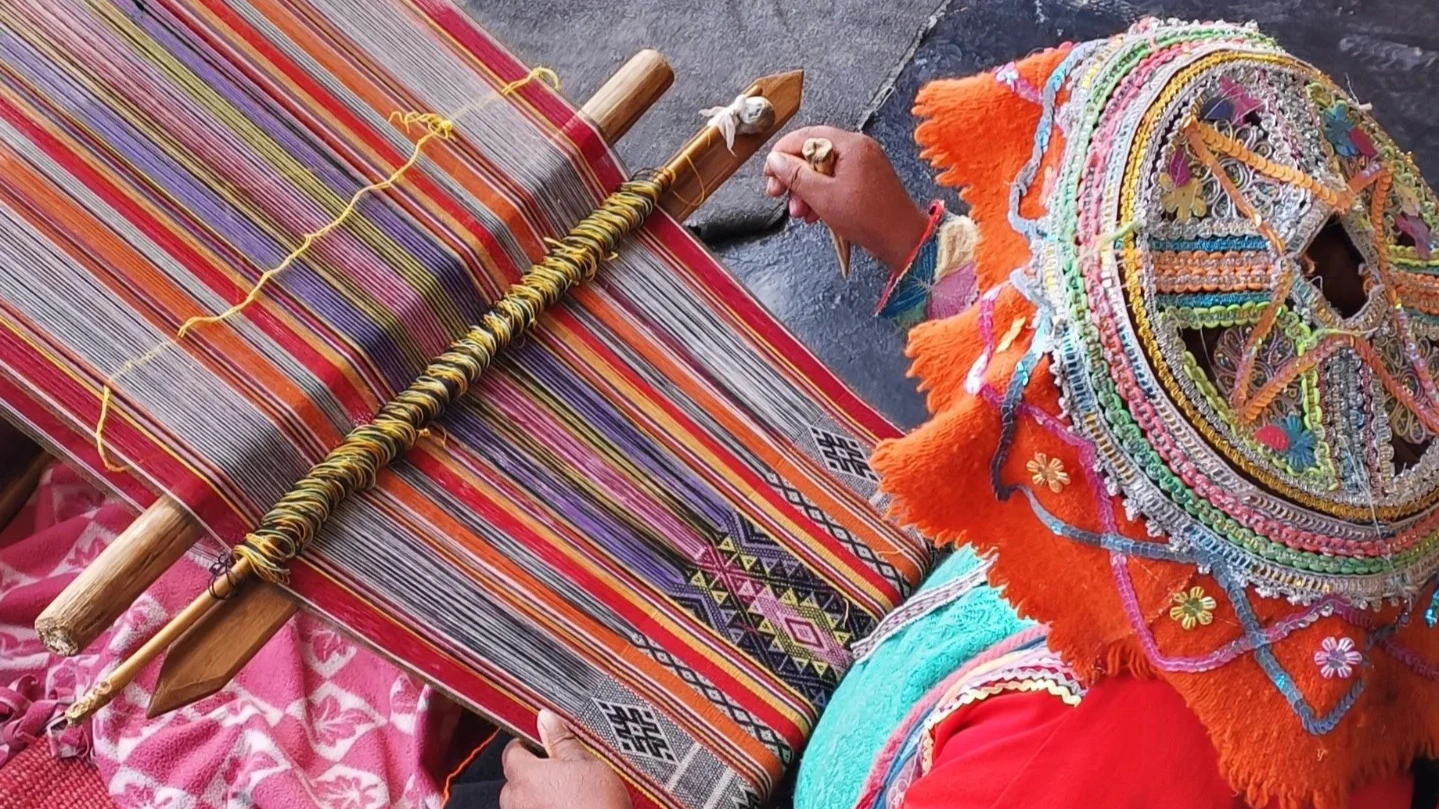 Artigiana indigena colombiana al telaio manuale mentre tesse un manufatto artigianale